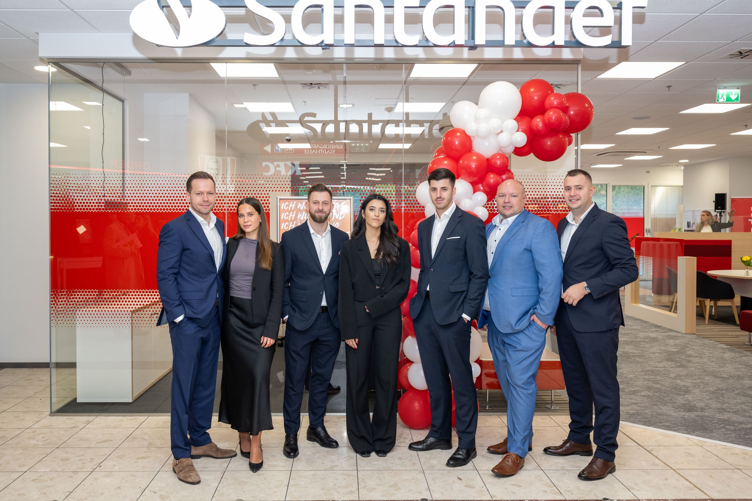 Das Filialteam steht vor dem Eingang der Santander-Filiale in der Lugner City.