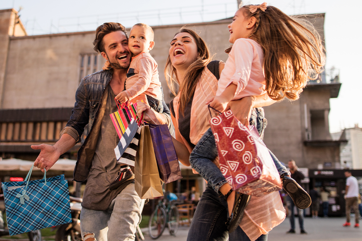 Glückliche Familie beim Einkaufen in der Stadt.