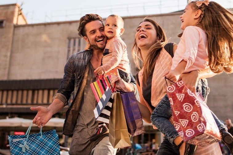 Glückliche Familie beim Einkaufen in der Stadt.