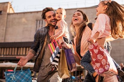 Glückliche Familie beim Einkaufen in der Stadt.