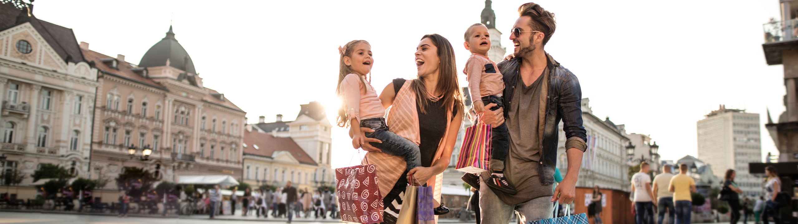Glückliche Familie beim Einkaufen in der Stadt.