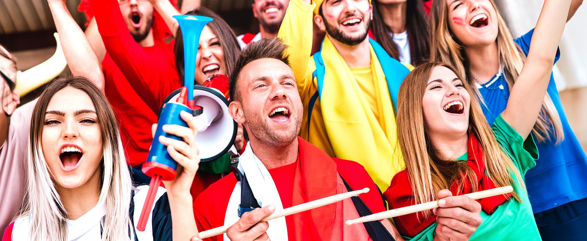 Fußballfans, die jubeln, während sie ein Fußballspiel auf den Tribünen des Stadions verfolgen.