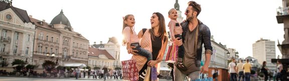 Glückliche Familie beim Einkaufen in der Stadt.
