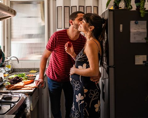Ein Ehemann und seine schwangere Frau kochen gemeinsam.
