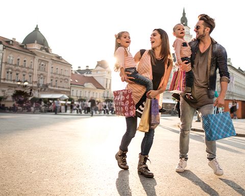 Glückliche Familie beim Einkaufen in der Stadt.